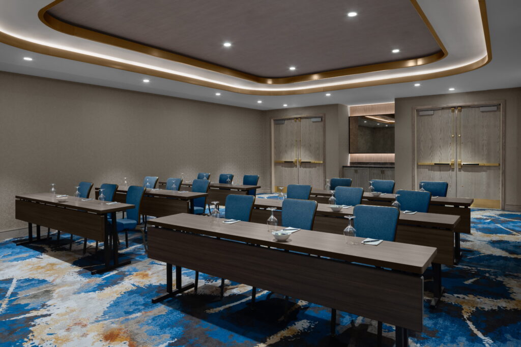 conference room with rows of wooden table and blue chairs