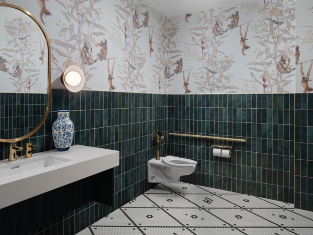 Prologue restroom with patterned wallpaper and green tile